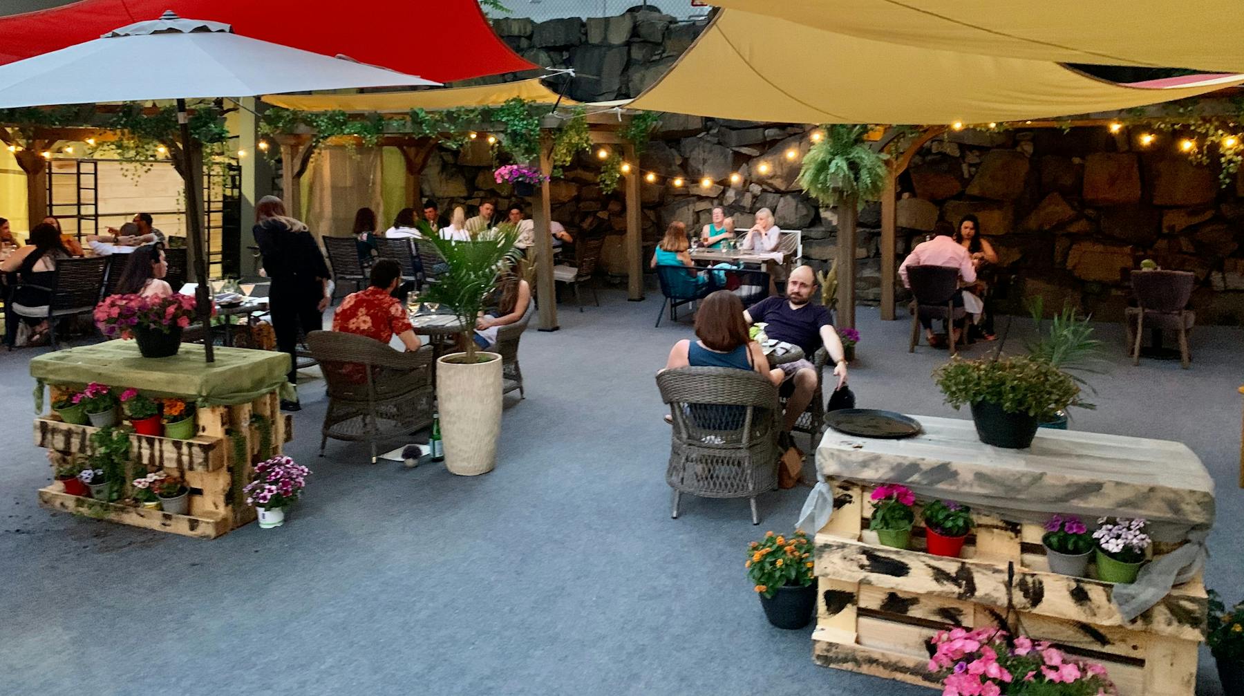 a group of people sitting at a table with an umbrella