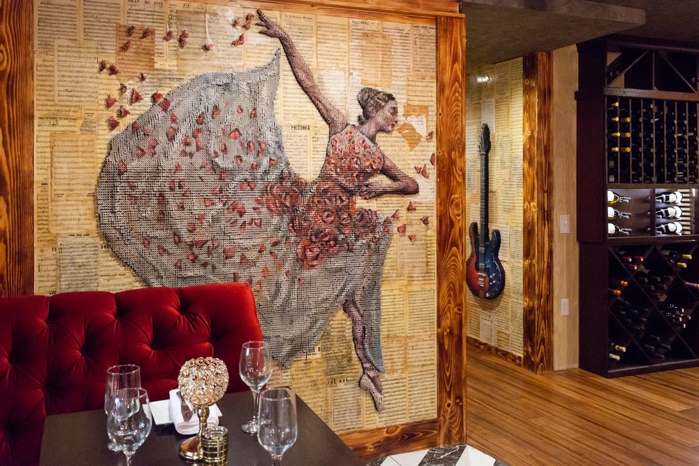 a person sitting at a table with a vase of flowers