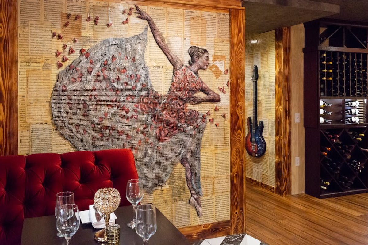 a person sitting at a table with a vase of flowers