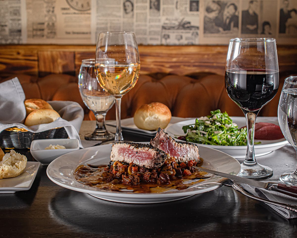 a plate of food and glasses of wine on a table