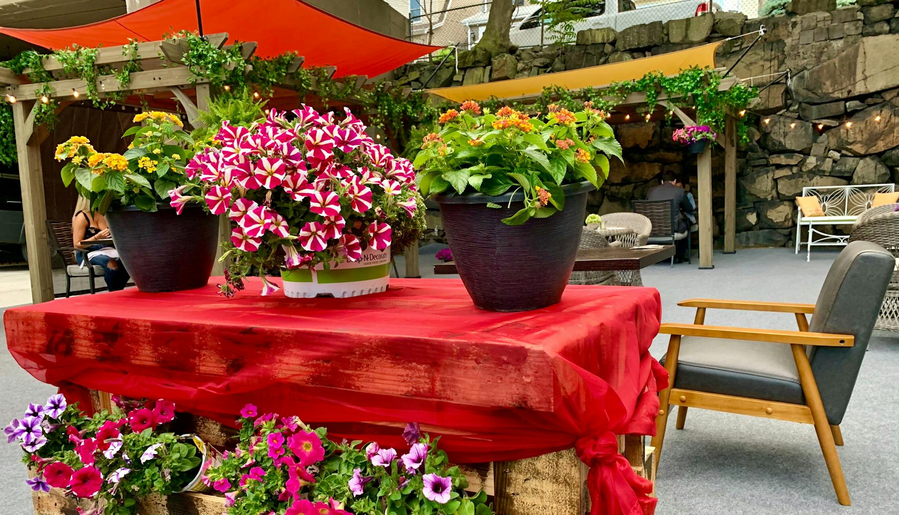 a large red chair in a garden