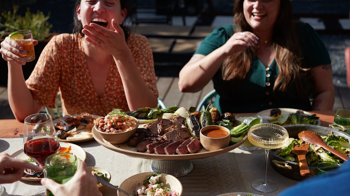 a woman sitting at a table with a plate of food