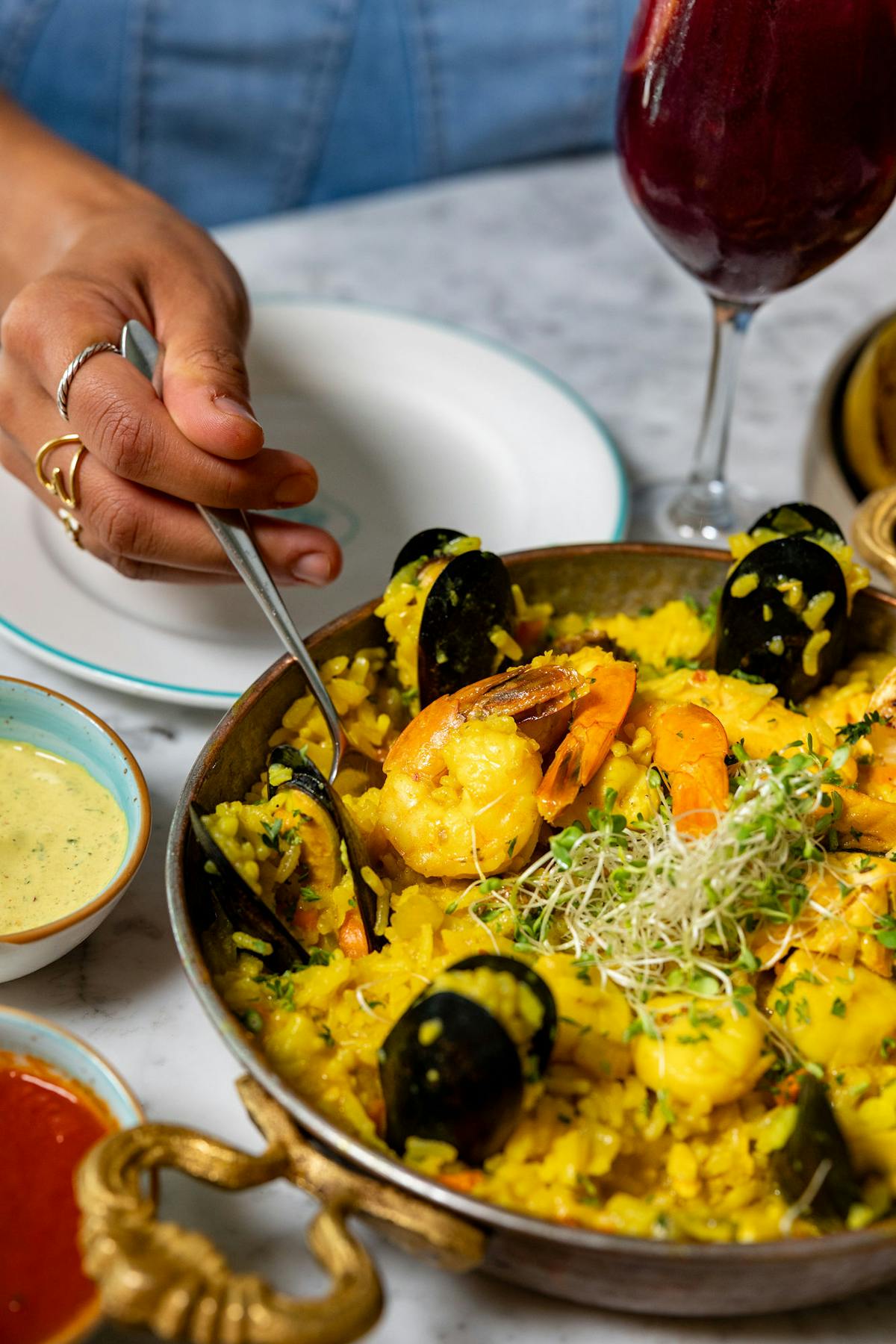 a person holding a plate of food on a table