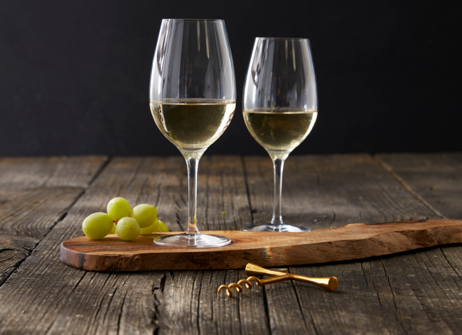 a glass of wine sitting on top of a wooden table