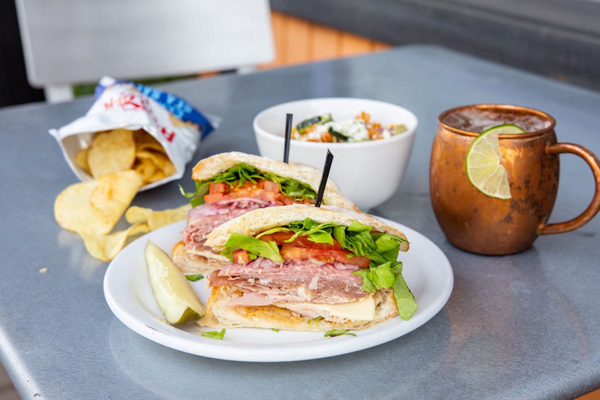 a sandwich sitting on top of a plate of food on a table