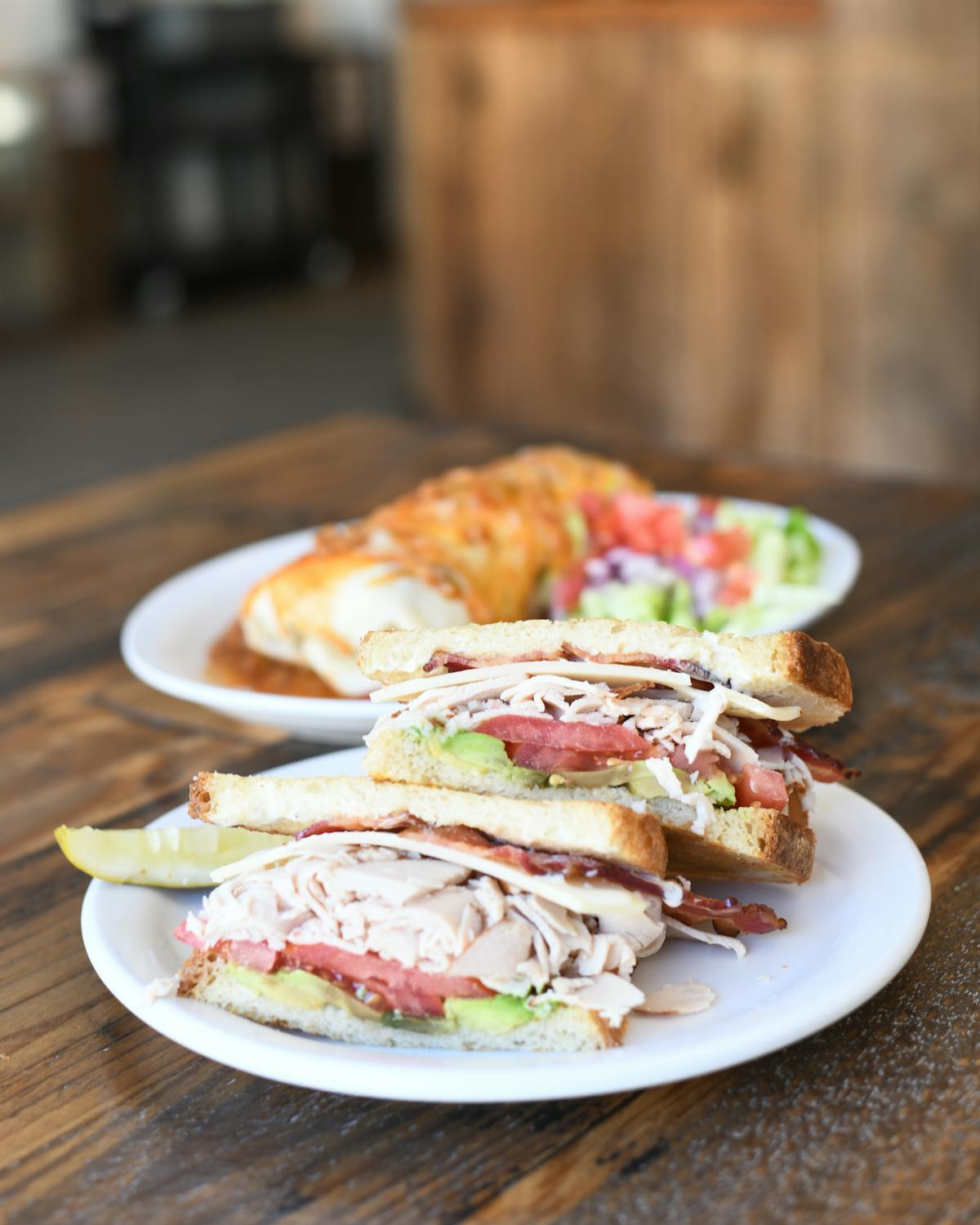 a sandwich sitting on top of a plate of food on a table