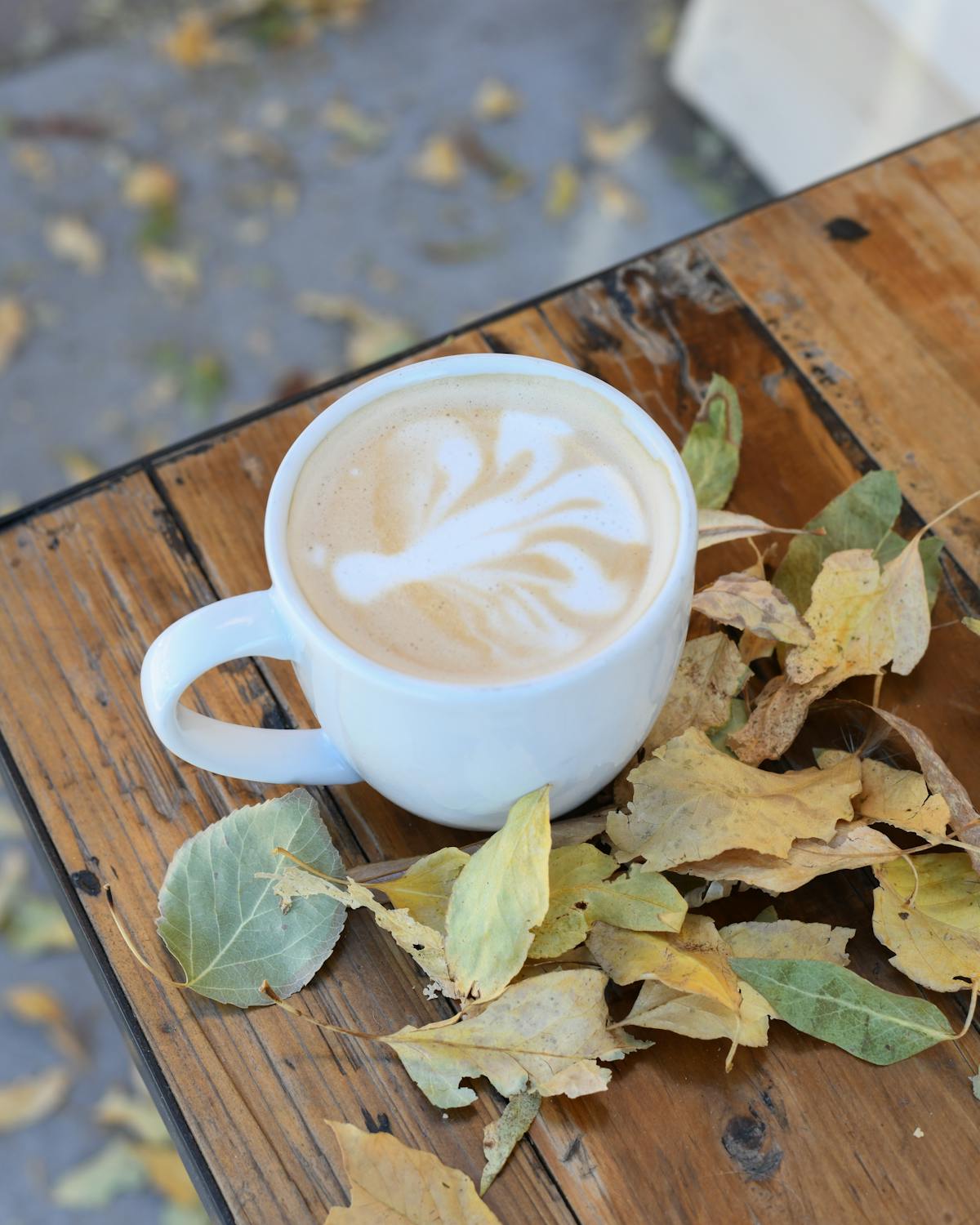 a cup of coffee sitting on top of a wooden table