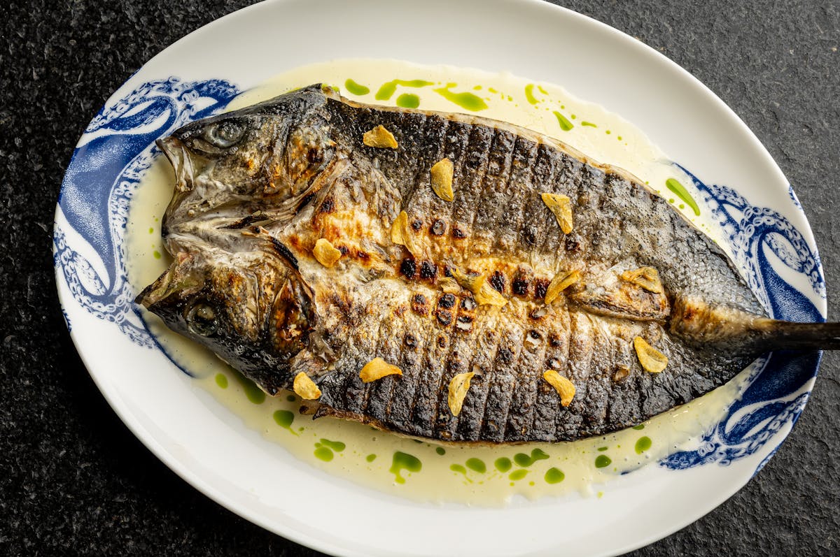 fish filet with crispy garlic over a creamy green sauce