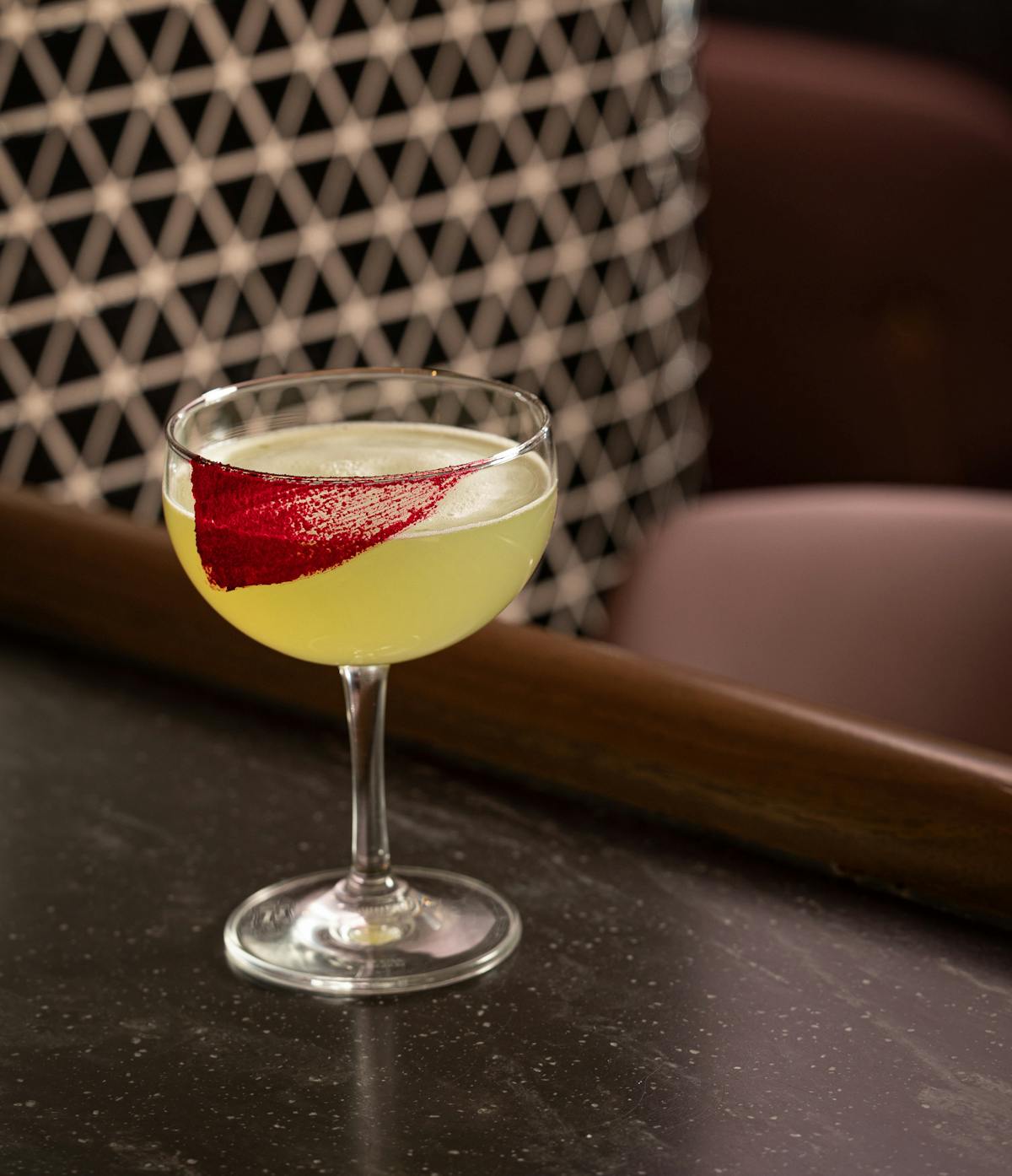 beverage in glass with red beet garnish