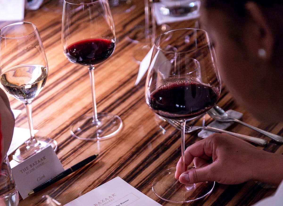 woman holding a glass of wine at a table