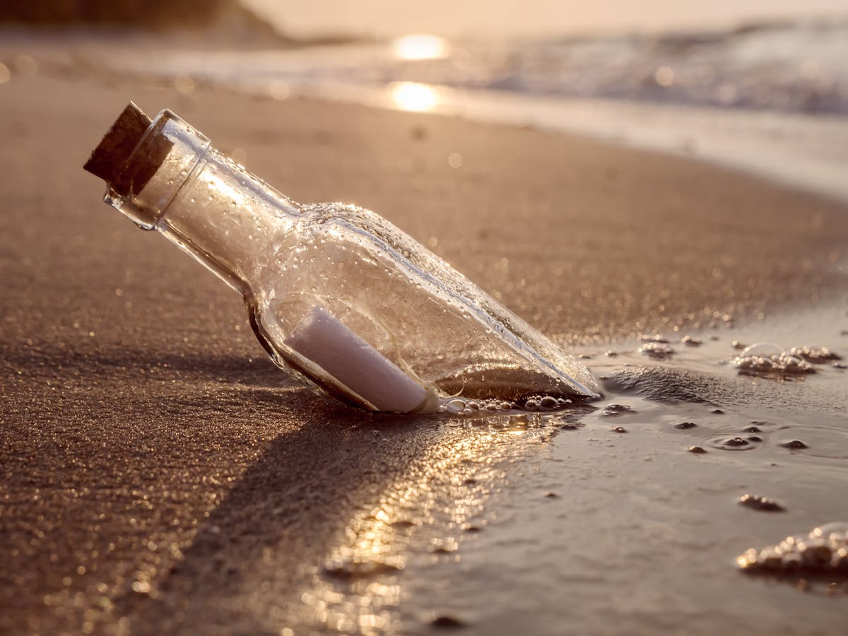 A bottle with a note inside washed along the shore of a beach
