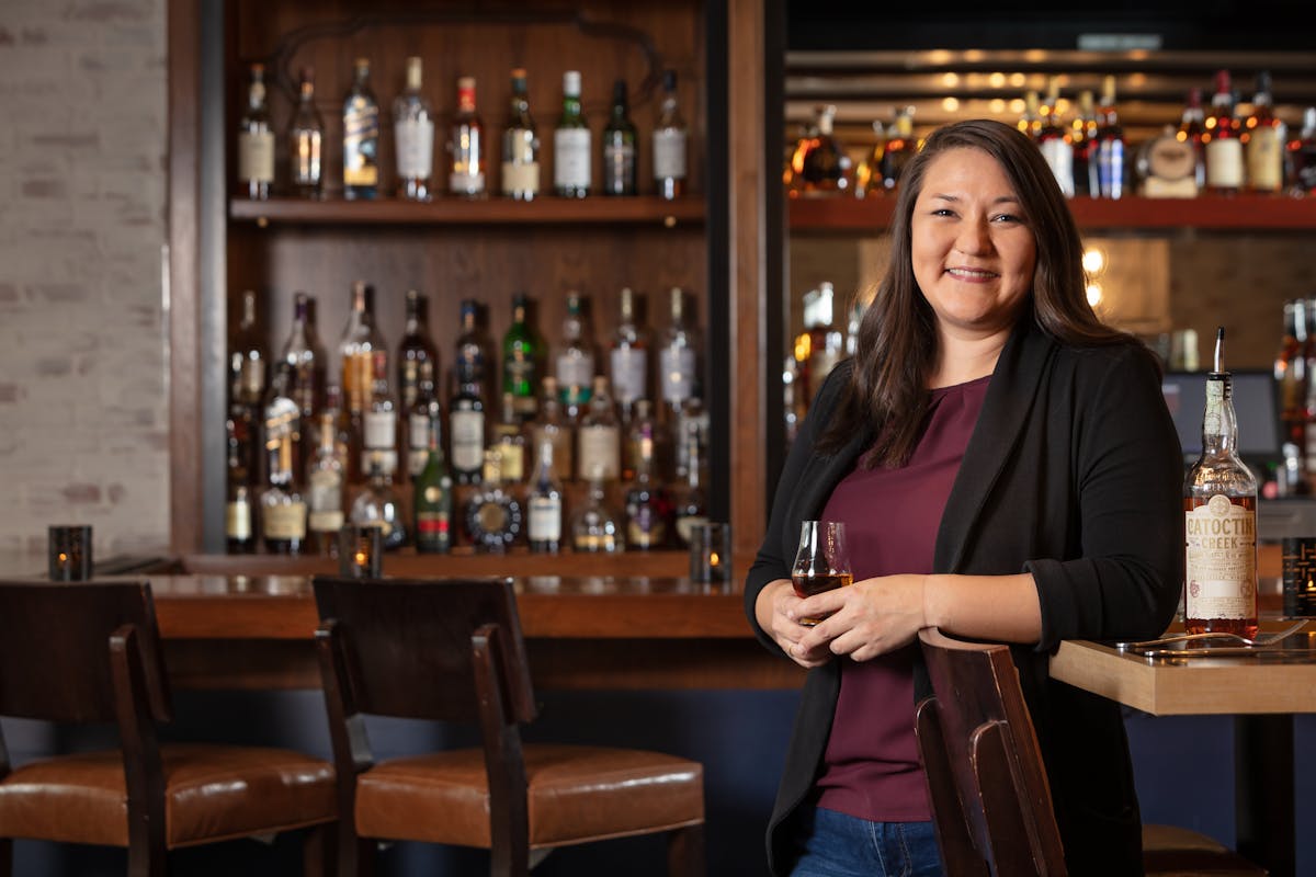 a woman sitting at a table with wine glasses
