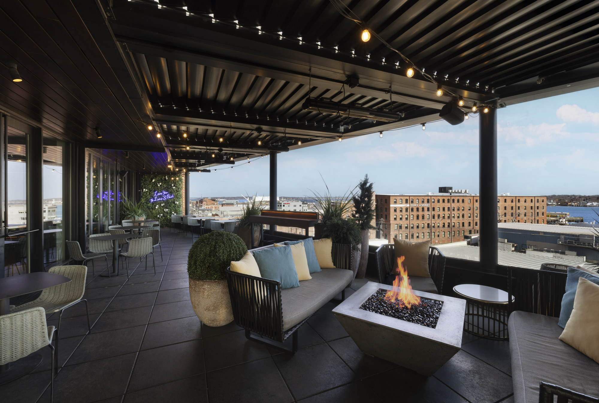 a patio with a fire pit and chairs