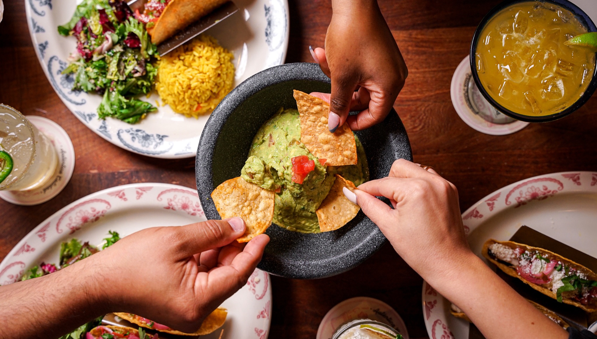 a person holding a plate of food on a table