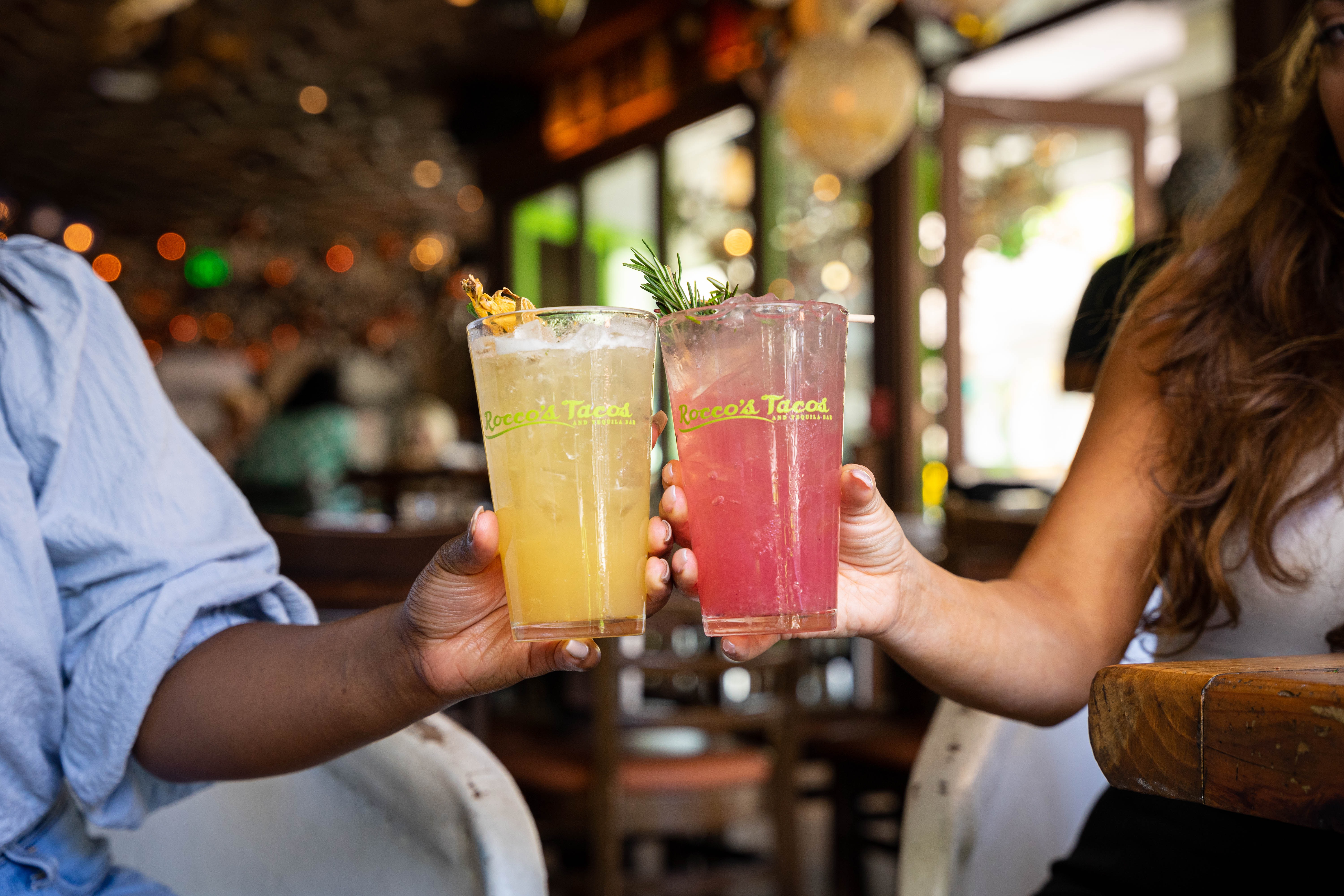 Two guests toasting cocktails in Rocco's Tacos glasses at Mother's Day brunch