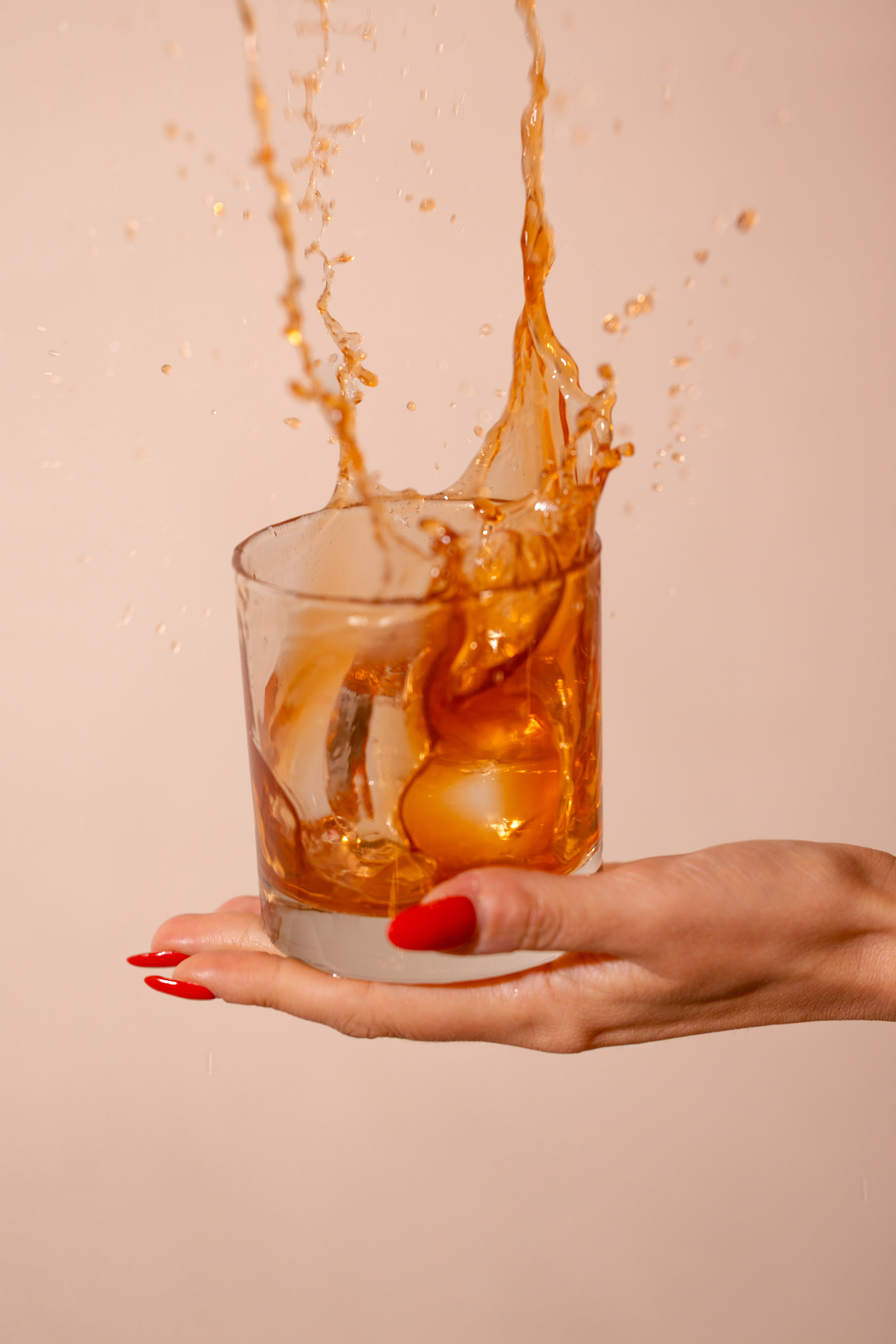 a hand holding a glass of orange juice