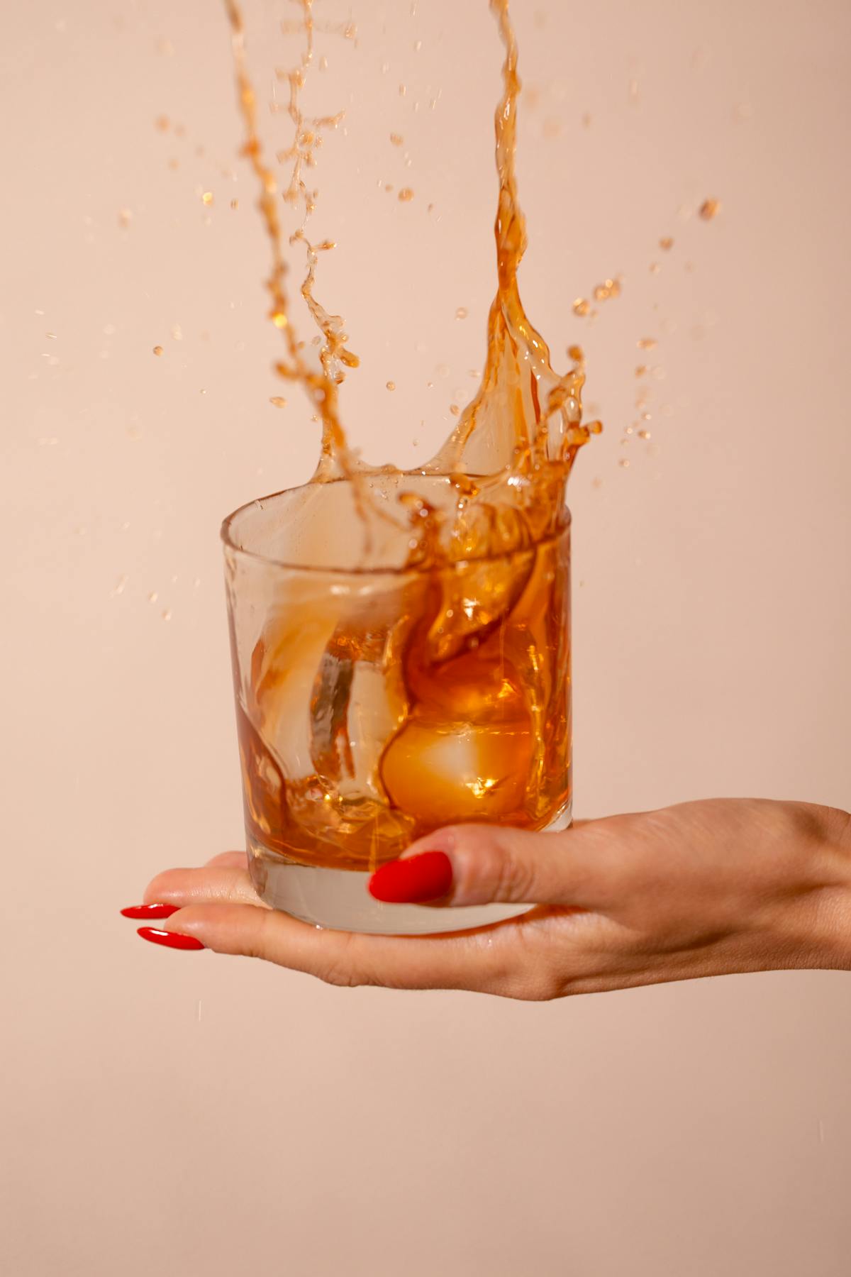 a hand holding a glass of orange juice