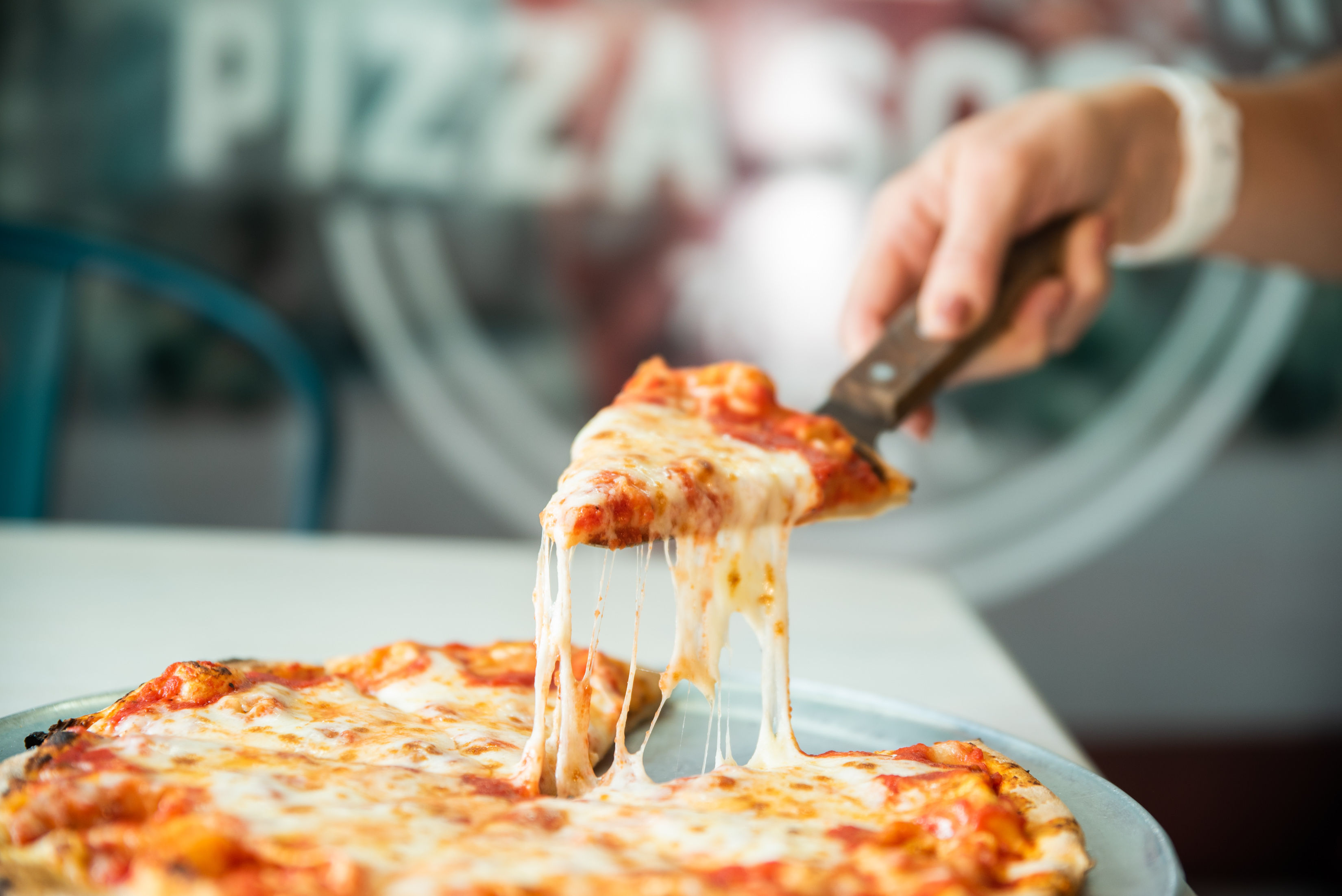a close up of a person holding a slice of pizza