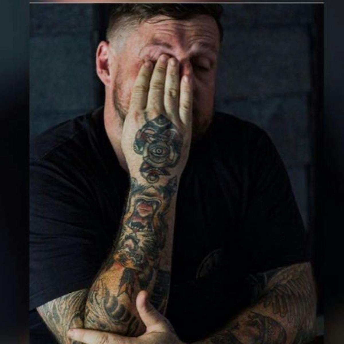 a man sitting in front of a tattoo