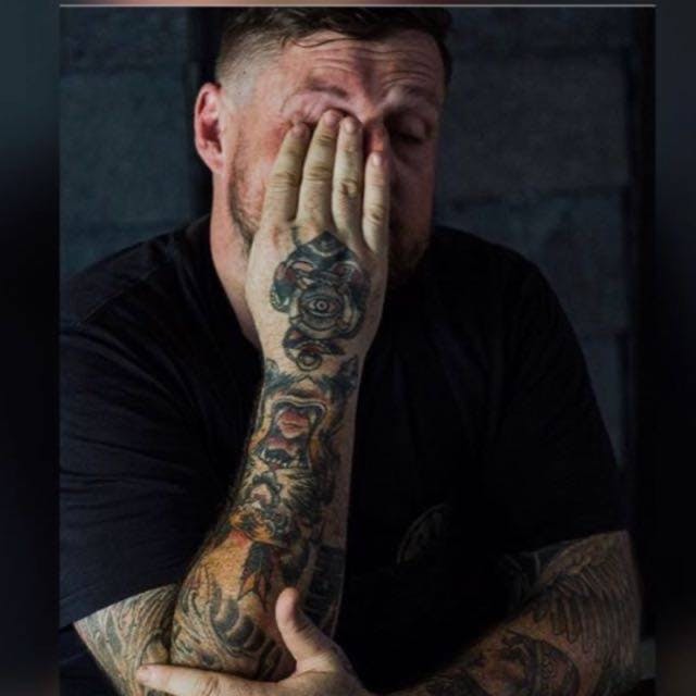 a man sitting in front of a tattoo