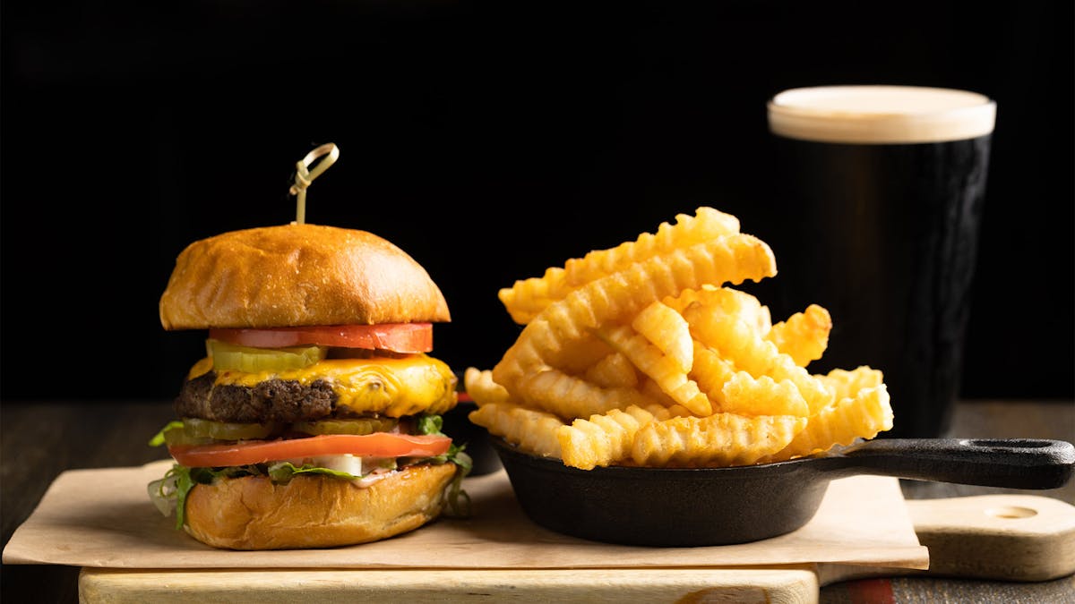 Rivercrest Standard burger, fries and beer on a wooden board