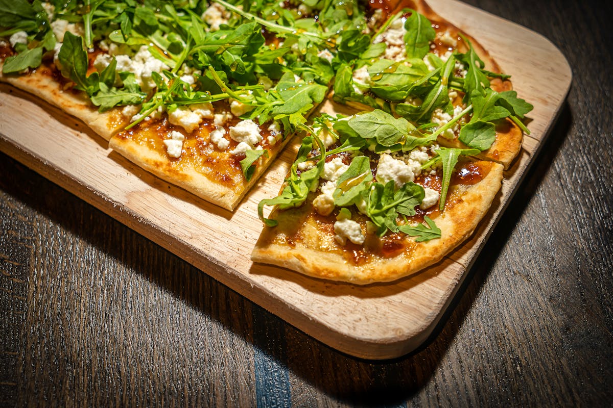 a pizza sitting on top of a wooden cutting board
