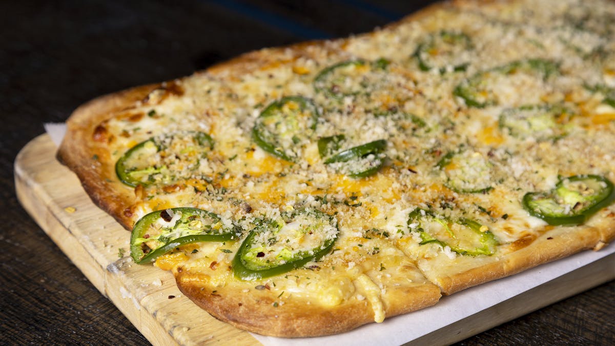 a pizza sitting on top of a wooden cutting board