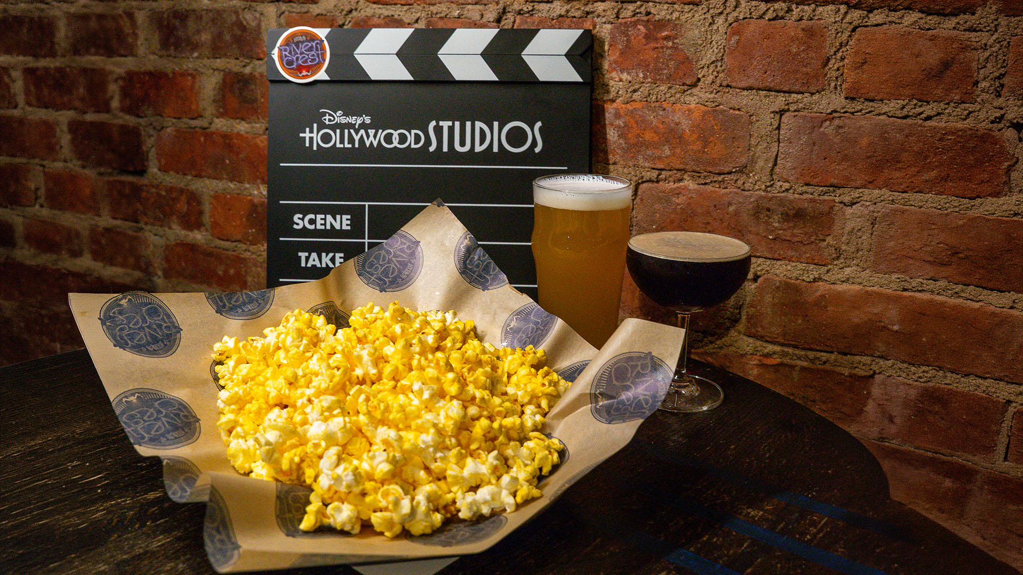 popcorn, beer, cocktail and a clapperboard on a wooden table at Rivercrest of the Oscars Viewing watch party