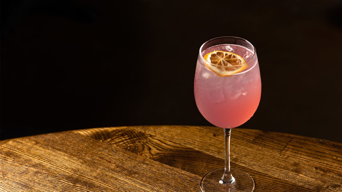 a glass of Rivercrest's new RC 75 cocktail on a wood table