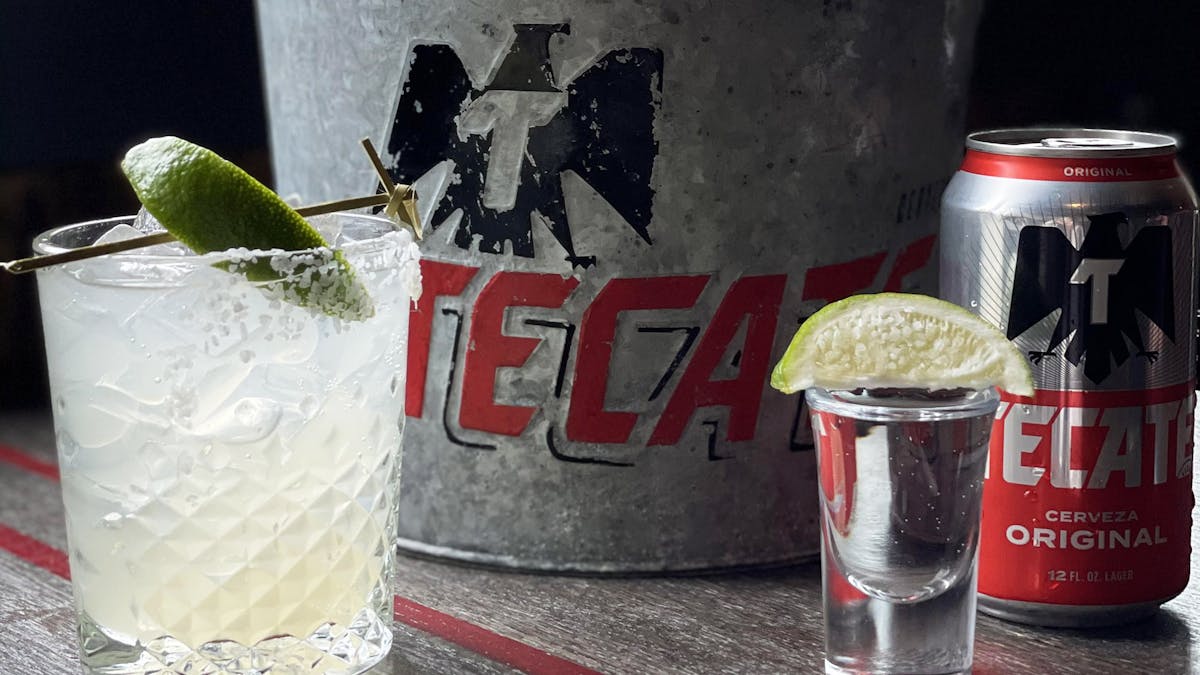 a glass of margarita, tequila shot and can of Tecate