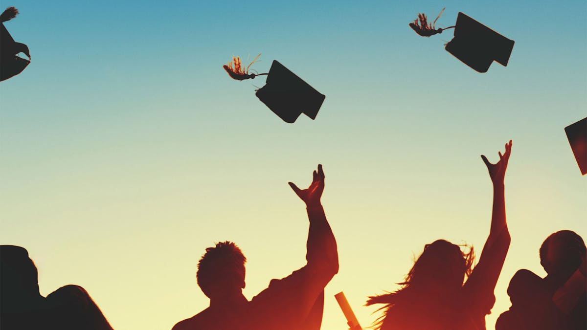 graduates throwing their caps in the air