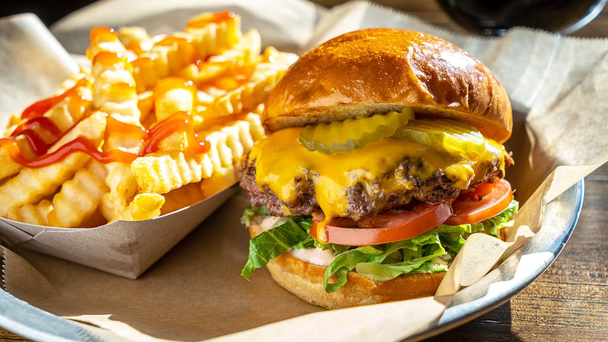 crinkle cut fries with Rivercrest cheeseburger on a plate