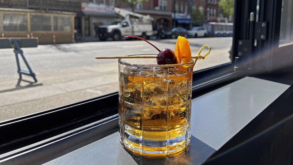a glass of our Rivercrest Old Fashioned on a window ledge