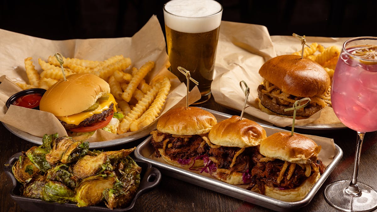 Photo of Rivercrest favorites: The Rivercrest Standard, Meatloaf Burger, BBQ Pulled Pork Sliders and Maple Fried Brussels Sprouts