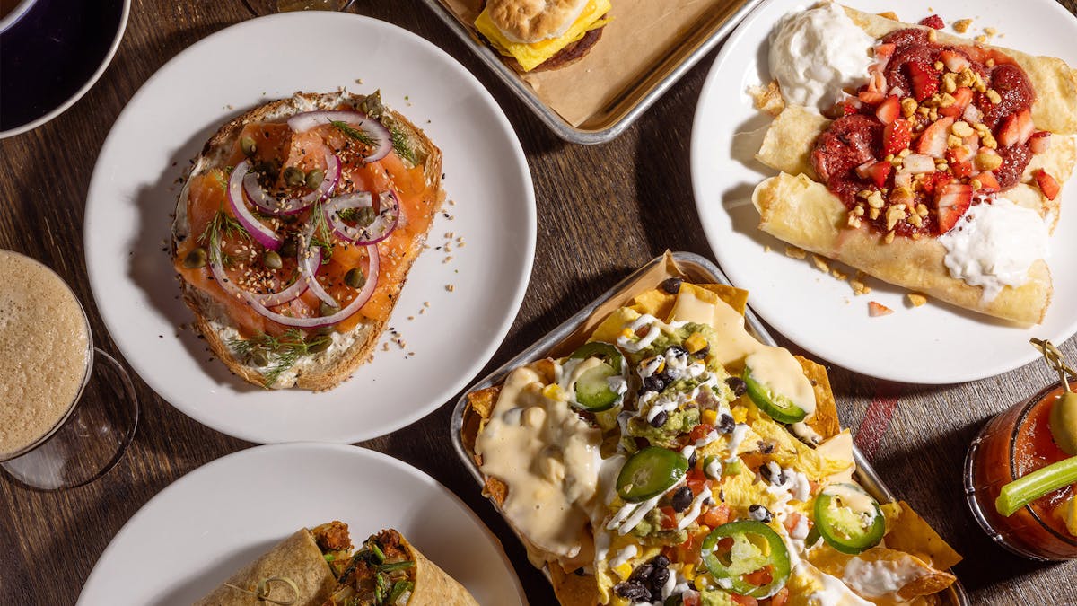Overhead shot of Rivercrest's new brunch dishes this Spring: Nachos Rancheros, Biscuit Sliders, Everything Lox Toast, Vegan Beyond Burrito, PB&J Crepes