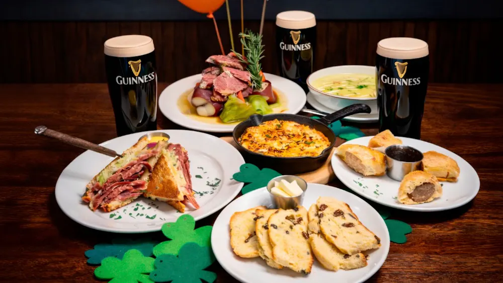 Rivercrest's St. Patrick's Day dishes with pints of Guinness on a wooden table in Astoria Queens