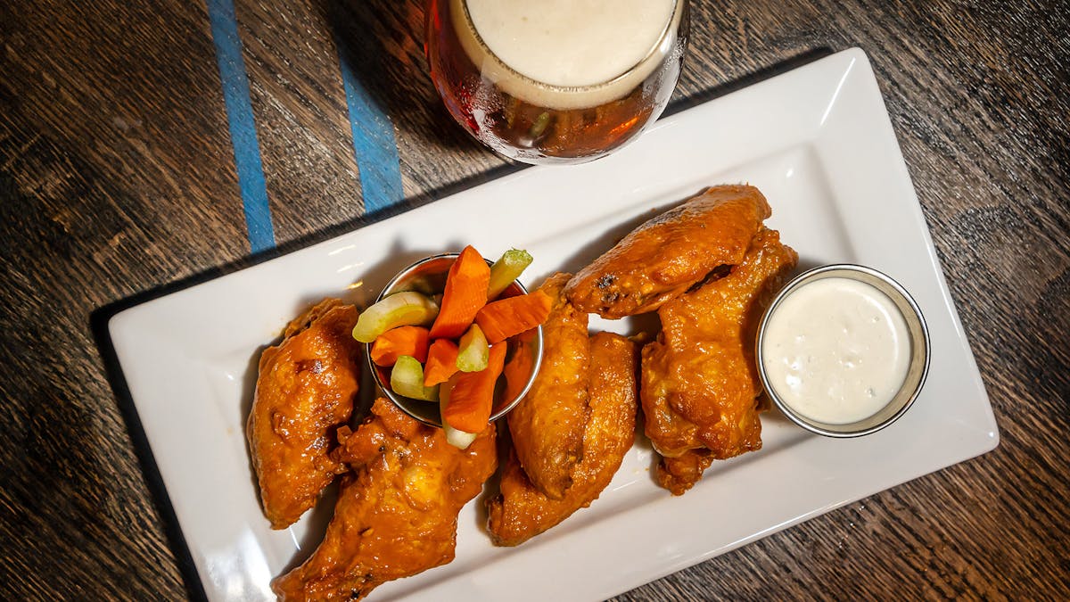 a plate of wings and beer on a table