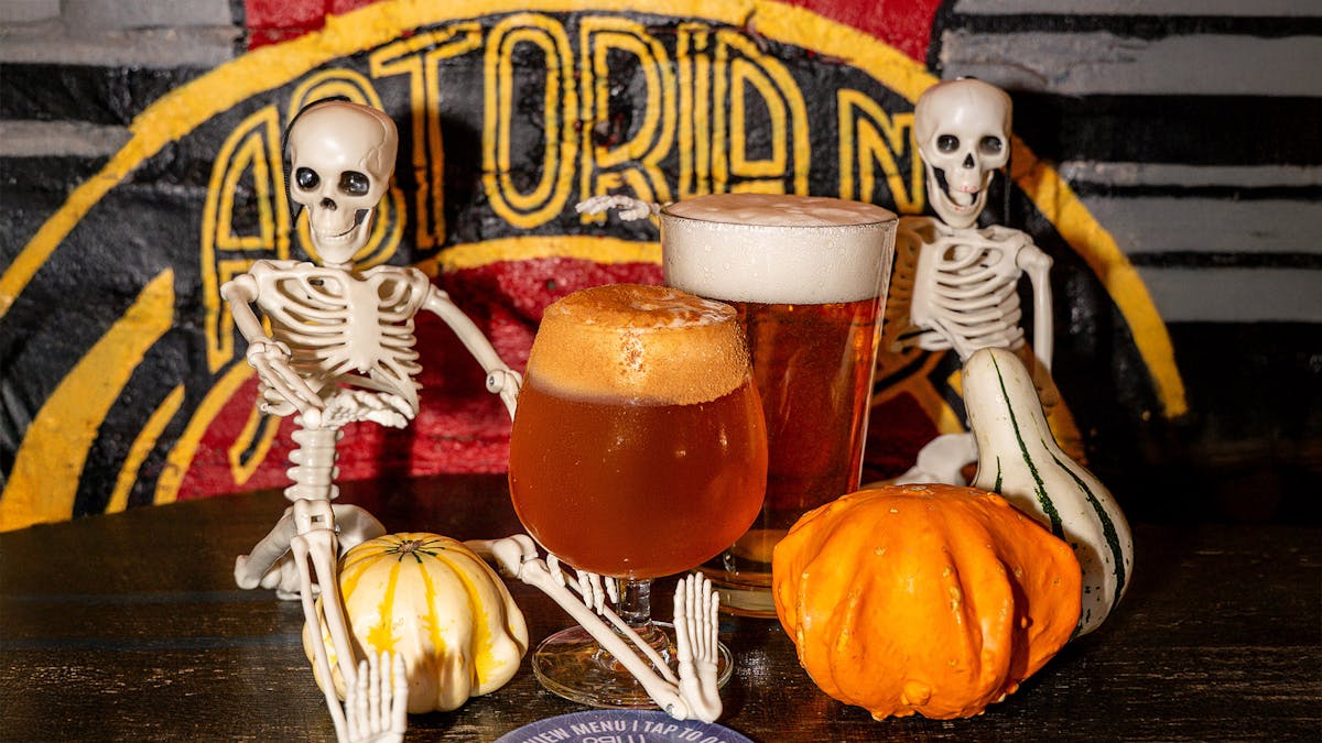 pumpkin beers with pumpkins and mini skeletons against Astoria wall