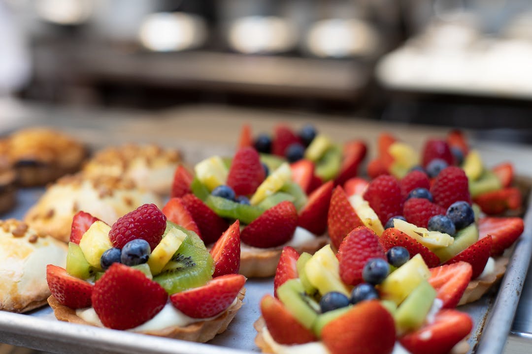 a close up of a cake with fruit on top of a table