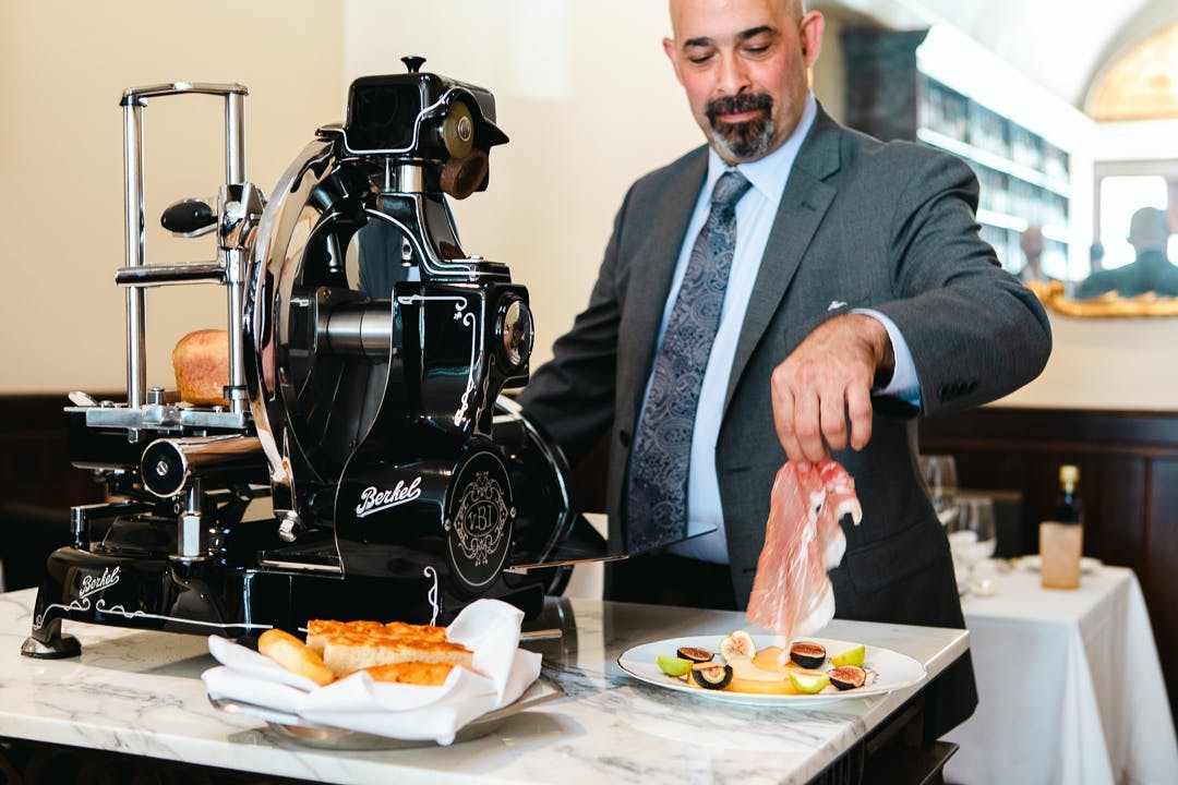a man holding a plate of food on a table