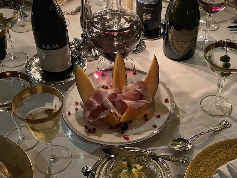 a plate of food and glasses of wine on a table