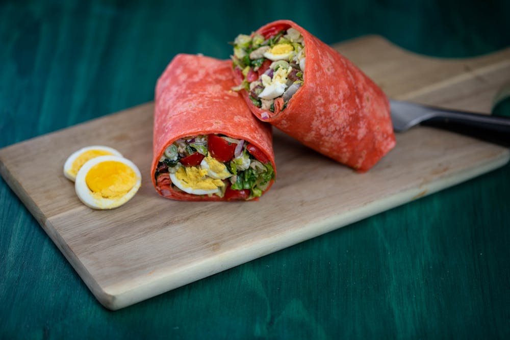 a slice of pizza sitting on top of a wooden cutting board