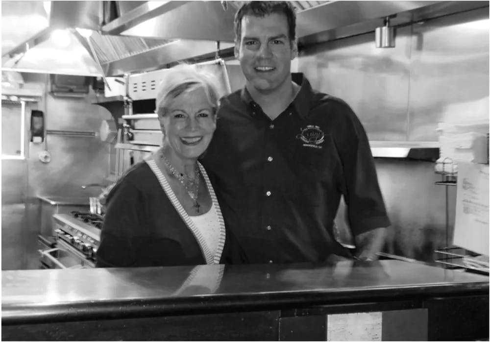 a man and woman preparing food in a kitchen