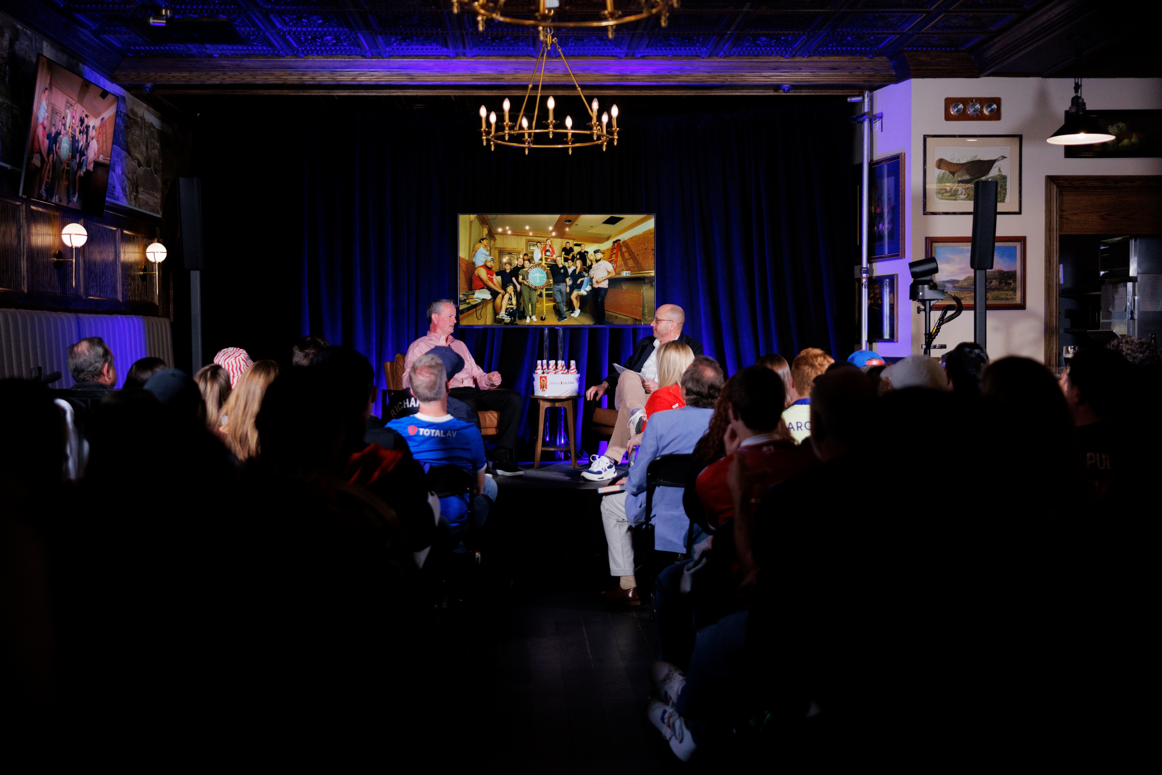 a group of people in a room with a television screen