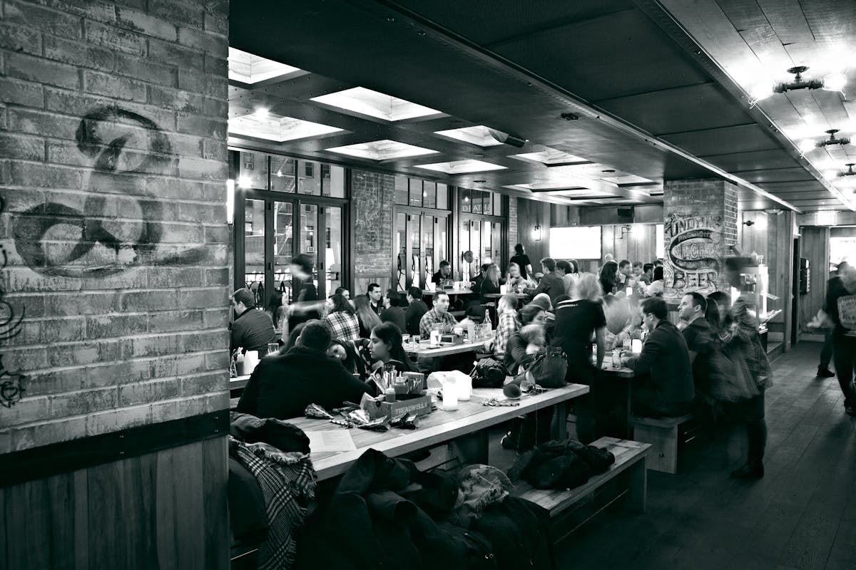 black and white photo of the restaurant, people eating and talking at the tables