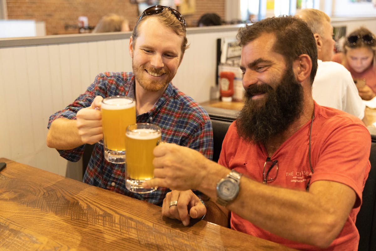 two people holding beer mugs