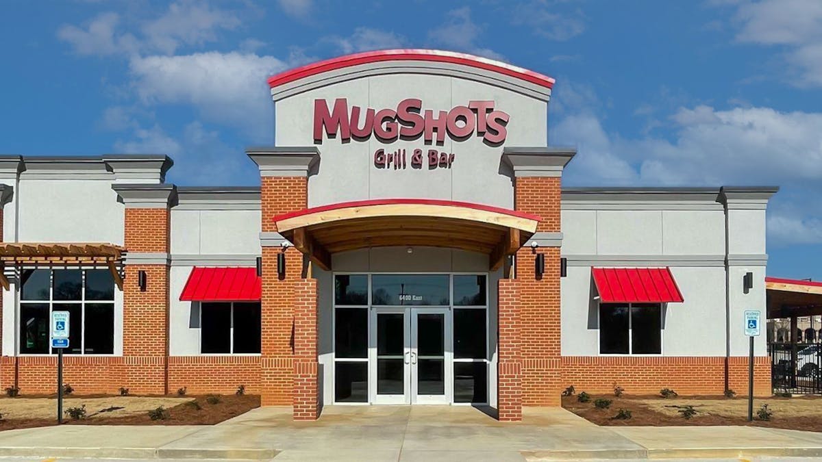 a large brick building with a sign in front of a house