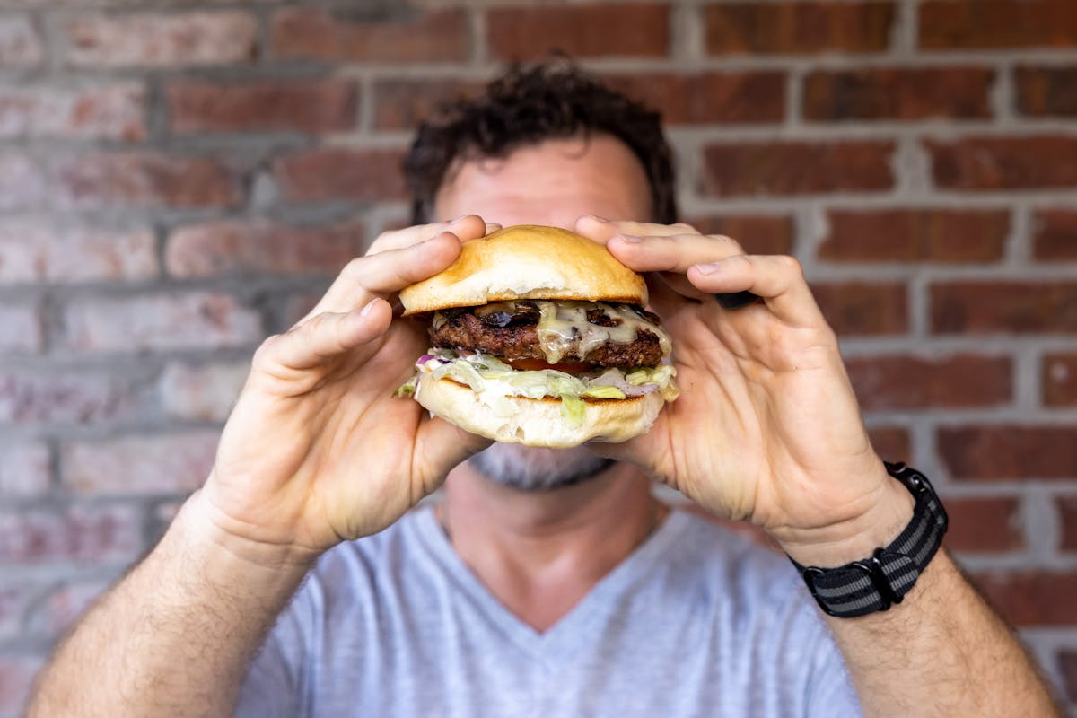 a person holding a burger