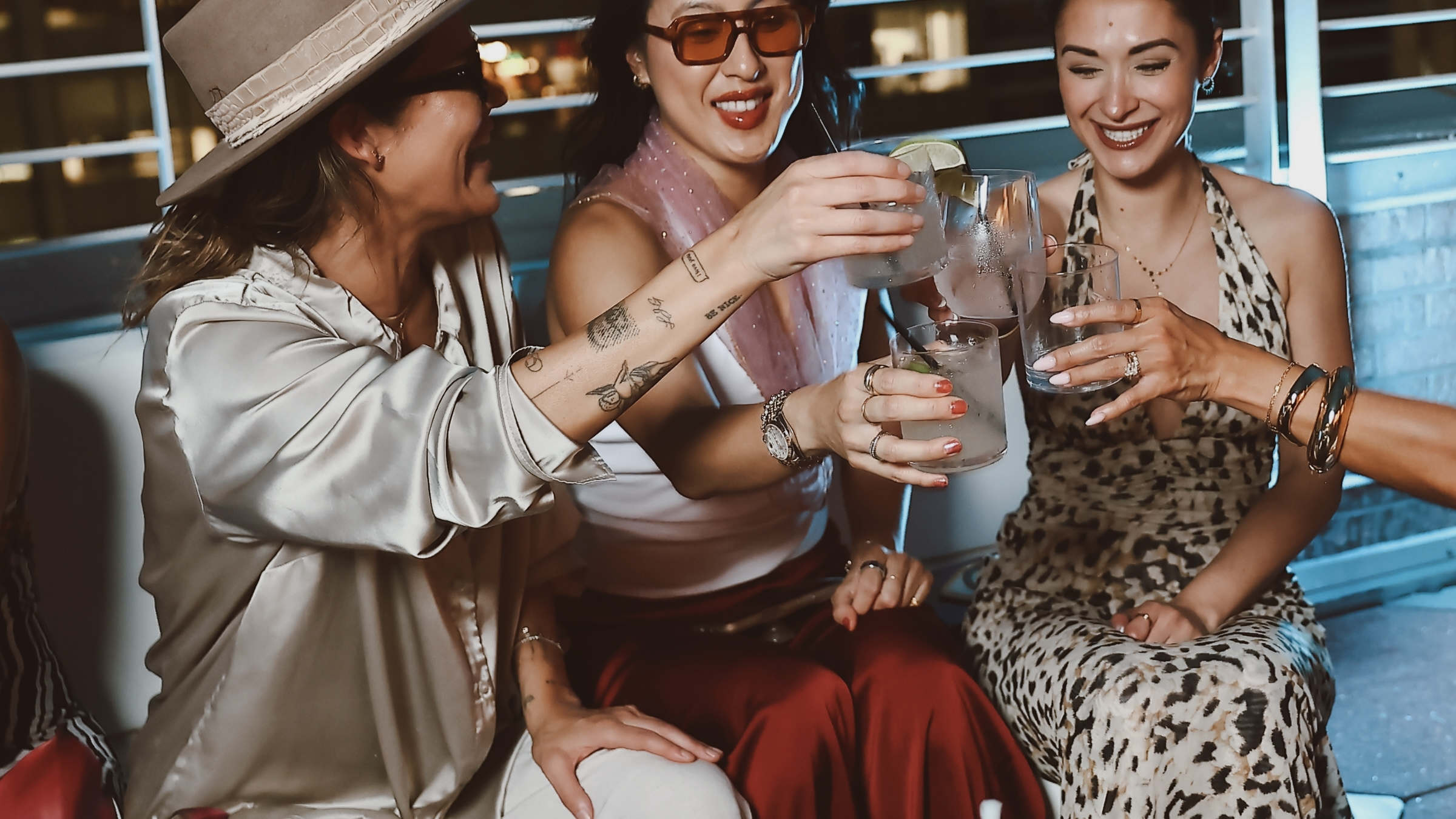 Stylish group of women clinking cocktail glasses at Z on 23 rooftop bar