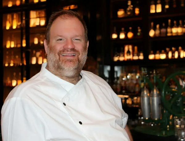 a man wearing glasses and smiling at the bar